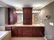 Bathroom features double vanity with dark wood cabinets and tub at 1000 Sarandon Dr, Matthews, NC 28104