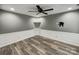 Neutral bonus room with white trim, accent wall, and wood-look floors, with a sleek black ceiling fan at 1000 Sarandon Dr, Matthews, NC 28104