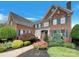 Charming brick home featuring lush landscaping, vibrant flowers, and a welcoming front entrance at 1000 Sarandon Dr, Matthews, NC 28104