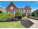 Beautiful brick home with manicured lawn, colorful landscaping, and classic blue shutters at 1000 Sarandon Dr, Matthews, NC 28104