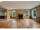 Bright living room featuring hardwood floors, fireplace, and wainscoting at 1000 Sarandon Dr, Matthews, NC 28104