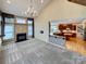 Spacious living room featuring a fireplace, chandelier, and seamless flow into the kitchen at 1000 Sarandon Dr, Matthews, NC 28104