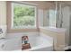 Soaking tub with a garden window and tiled shower in this bright, modern bathroom at 1051 Streamlet Way, Monroe, NC 28110