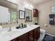 Bathroom featuring double sinks, cherry wood cabinets, tiled flooring, and decorative mirrors at 1051 Streamlet Way, Monroe, NC 28110