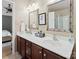 Bathroom featuring double sinks, cherry wood cabinets, tiled flooring, and decorative mirrors at 1051 Streamlet Way, Monroe, NC 28110