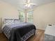 Bright bedroom featuring hardwood floors, two windows, neutral colored walls, and modern ceiling fan at 1051 Streamlet Way, Monroe, NC 28110
