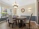 Traditional dining room with a rustic table, elegant chandelier and large bay window at 1051 Streamlet Way, Monroe, NC 28110