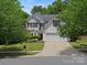 Charming two-story home with a well-manicured lawn, mature landscaping, and a two-car garage at 1051 Streamlet Way, Monroe, NC 28110
