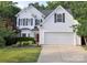Charming two-story home with a well-manicured lawn, a two-car garage and a striking red front door at 1051 Streamlet Way, Monroe, NC 28110
