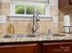 Close-up on a stainless steel kitchen sink with a window view and granite countertops at 1051 Streamlet Way, Monroe, NC 28110
