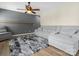 Living room with a comfy gray sofa, ceiling fan, and neutral decor for a relaxing ambiance at 1051 Streamlet Way, Monroe, NC 28110