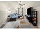 Spacious living room with a blue sectional sofa, large television and a modern ceiling fan at 1051 Streamlet Way, Monroe, NC 28110