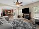 Open concept living room with hardwood floors, fireplace, view to kitchen and adjacent dining area at 1051 Streamlet Way, Monroe, NC 28110