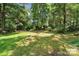 Lush backyard with mature trees providing ample shade and a charming picnic area at 1134 Willow Oaks Trl, Matthews, NC 28104