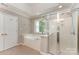 Bathroom with a glass-enclosed shower and separate soaking tub, complemented by a view of lush greenery at 1147 Anduin Falls Dr, Charlotte, NC 28269