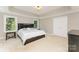 Bedroom with a bed with drawer storage, plush carpet, and a window overlooking lush greenery at 1147 Anduin Falls Dr, Charlotte, NC 28269
