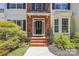 Inviting front entrance features a black door, brick steps, and lush landscaping at 1147 Anduin Falls Dr, Charlotte, NC 28269