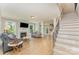 Bright living room featuring hardwood floors, a fireplace, and elegant staircase at 1147 Anduin Falls Dr, Charlotte, NC 28269