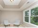 Sitting room with tray ceiling, two chairs and a large window overlooking lush greenery at 1147 Anduin Falls Dr, Charlotte, NC 28269