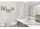 Bright bathroom features framed bee prints, neutral vanity, and glass enclosed shower at 11619 Sapsucker Ln # 65, Charlotte, NC 28215