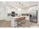 Modern kitchen with white cabinets, stainless steel appliances, a center island and pendant lighting at 11619 Sapsucker Ln # 65, Charlotte, NC 28215
