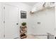 Convenient laundry room with tiled floor, open shelving, and decorative rolling cart at 11619 Sapsucker Ln # 65, Charlotte, NC 28215