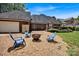 Spacious backyard featuring a fire pit area with gravel, surrounded by comfortable seating and lush green lawn at 117 Lake Hills Dr, Mooresville, NC 28117