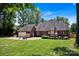 Back exterior view of a brick home, showcasing its well-maintained lawn, patio, and attached garage at 117 Lake Hills Dr, Mooresville, NC 28117