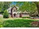 Traditional two-story home with a lush green lawn and mature trees offering ample shade at 117 Lake Hills Dr, Mooresville, NC 28117