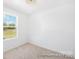 Bright, minimalist bedroom featuring a large window with scenic outdoor views and neutral carpeted floors at 11716 Avocet St # 75, Charlotte, NC 28215