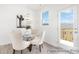 Cozy dining area boasts bright light, contemporary chandelier, glass top table, and deck access at 11716 Avocet St # 75, Charlotte, NC 28215
