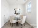 Cozy dining area features a contemporary chandelier, glass top table, and bright light at 11716 Avocet St # 75, Charlotte, NC 28215