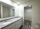 Bathroom featuring double sink vanity with granite countertop, large mirror, walk in closet and tiled floor at 139 Dove Creek Trl, Statesville, NC 28625