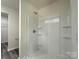 Bathroom featuring walk-in shower with a white shower stall, built-in shelves, and sleek chrome fixtures at 139 Dove Creek Trl, Statesville, NC 28625