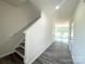 Bright entryway featuring sleek laminate flooring, a staircase leading to the second floor, and doors to other rooms at 139 Dove Creek Trl, Statesville, NC 28625