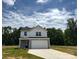 Two-story home featuring white siding and stone accents, complemented by an attached two-car garage and newly poured driveway at 139 Dove Creek Trl, Statesville, NC 28625