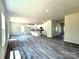 Bright, open-concept living room and kitchen featuring sleek laminate flooring, white kitchen cabinets, and ample natural light at 139 Dove Creek Trl, Statesville, NC 28625