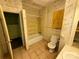 Bathroom featuring a tub and shower, toilet, tile flooring and wallpaper at 1445 33Rd Sw St, Hickory, NC 28602