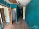 Spacious hallway with original hardwood flooring and teal walls, offering a unique vintage aesthetic at 1445 33Rd Sw St, Hickory, NC 28602