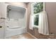 Bathroom showcasing a bathtub and a window with white curtains at 147 35Th Ne Ave, Hickory, NC 28601