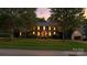 Two-story brick home with a well-maintained lawn at dusk, framed by mature trees at 147 35Th Ne Ave, Hickory, NC 28601