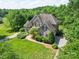 Aerial view of a beautiful brick home with a manicured lawn, mature trees, and a long concrete driveway at 1508 Avalon Oaks Ct, Dallas, NC 28034