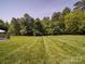 Expansive green backyard with neatly striped lawn and mature trees, providing ample space for outdoor activities at 1508 Avalon Oaks Ct, Dallas, NC 28034