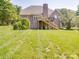 Rear view of home with stairs leading to an upper deck, overlooking a manicured lawn at 1508 Avalon Oaks Ct, Dallas, NC 28034