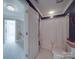 Neutral bathroom with white fixtures, shower with curtain, and storage. View into connecting room at 1508 Avalon Oaks Ct, Dallas, NC 28034