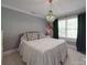Bedroom with gray walls, white bedding, decorative chandelier, and windows with dark-green curtains at 1508 Avalon Oaks Ct, Dallas, NC 28034