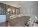 The dining room features colorful wallpaper, a modern light fixture, wainscoting and a long dining table at 1508 Avalon Oaks Ct, Dallas, NC 28034