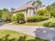 Side view of an attractive brick home with a well-manicured lawn, mature trees, and a long concrete driveway at 1508 Avalon Oaks Ct, Dallas, NC 28034