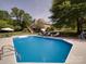 Backyard pool with sun loungers, umbrella, and trees, creating a serene outdoor retreat at 1508 Avalon Oaks Ct, Dallas, NC 28034