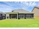 A modern home features a large backyard with ample green space and a covered patio at 163 Crenshaw Nw Pl, Concord, NC 28027